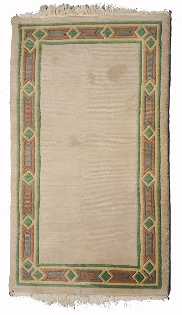 Appraisal: A NEPALESE WHITE WOOLLEN RUG with a simple pastel coloured