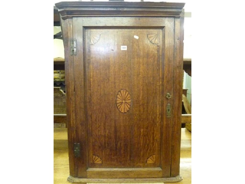 Appraisal: A Georgian oak hanging corner cupboard enclosed by a panelled