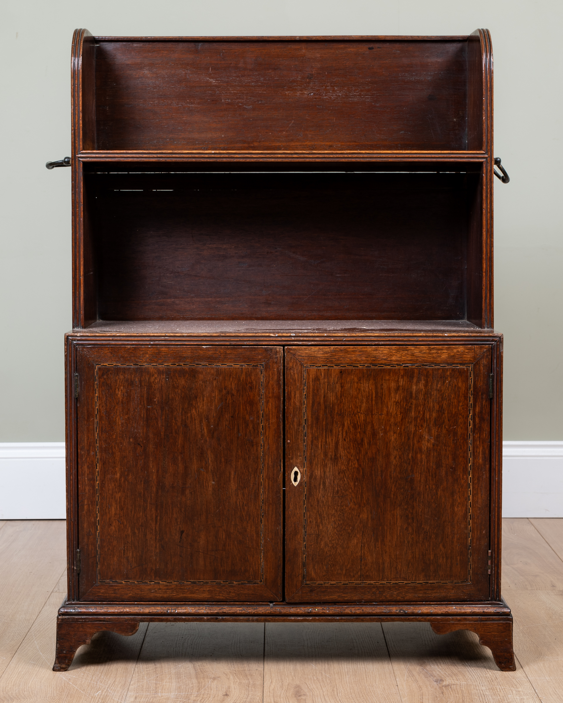 Appraisal: An early th century mahogany low bookcase with brass carrying