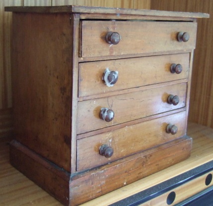 Appraisal: A pine miniature four drawer chest on a plinth base