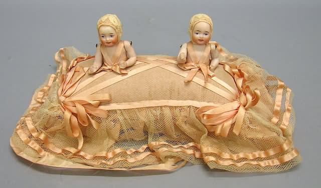 Appraisal: All bisque twins on pin cushion Pair of painted eye