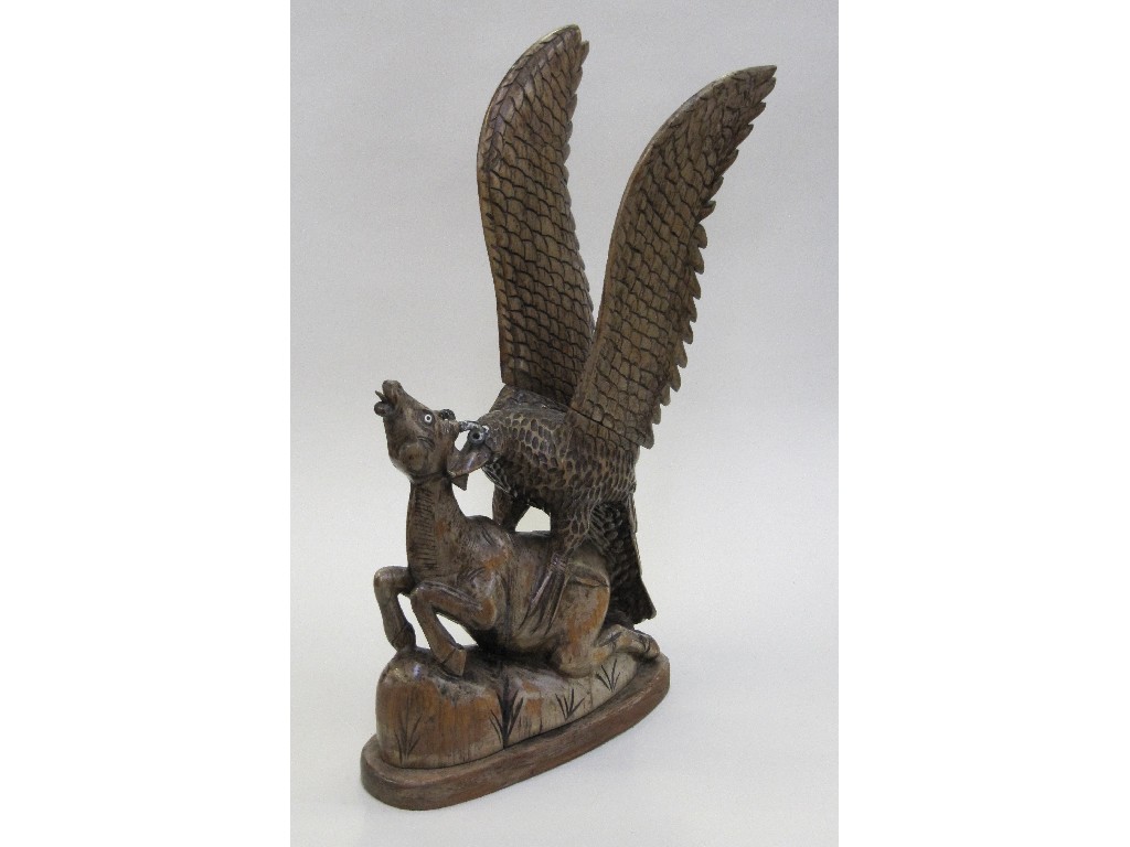 Appraisal: Carved wooden figure of an eagle attacking its prey