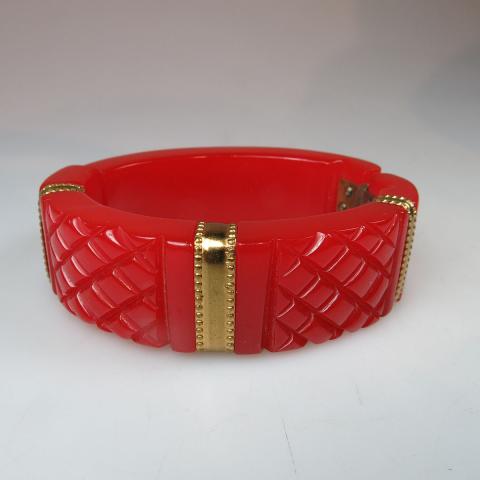 Appraisal: Red Bakelite Spring Hinged Bangle with overlain gold-tone metal decoration