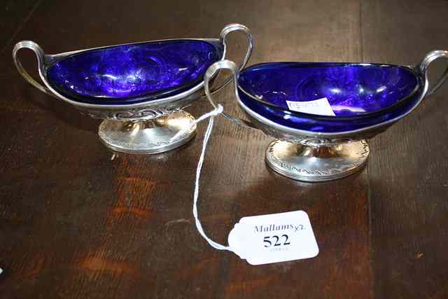 Appraisal: A PAIR OF GEORGE III OVAL SALTS with scrolled handles