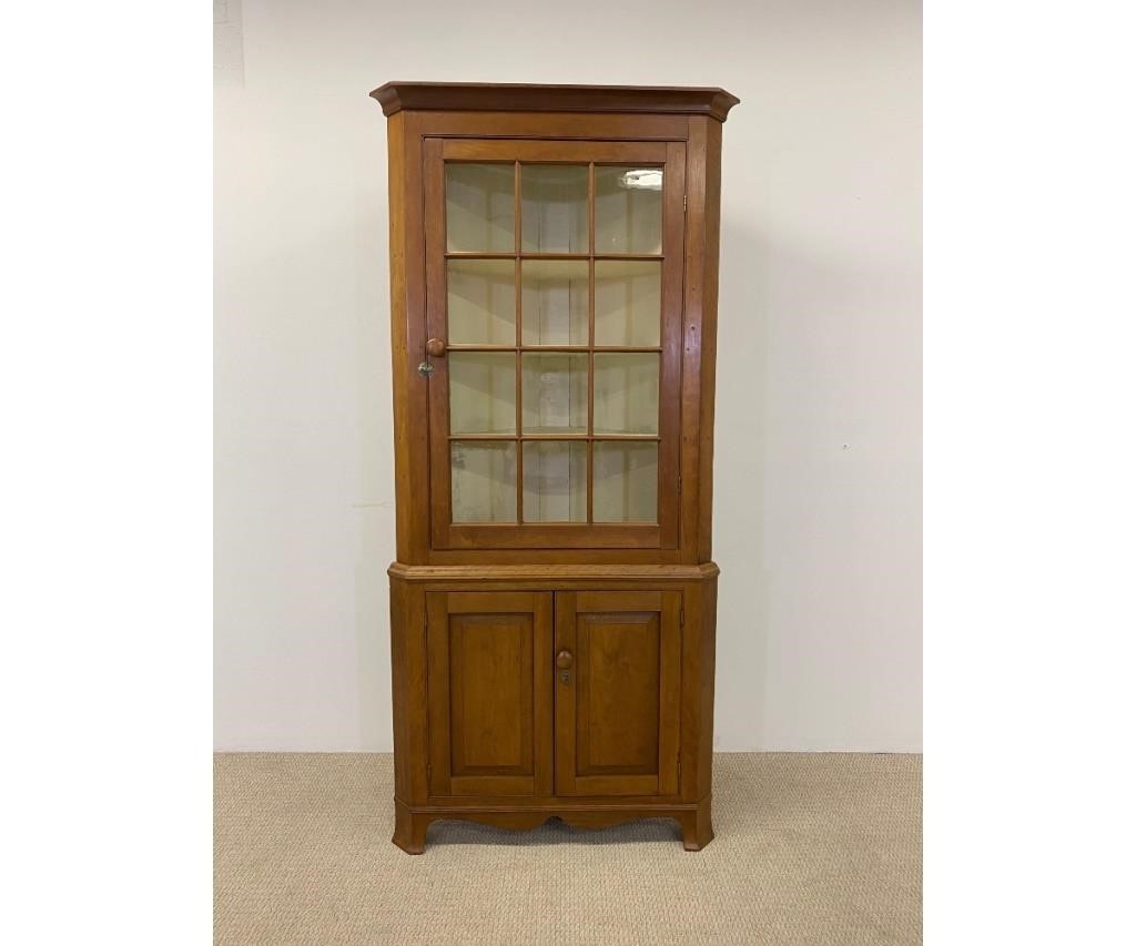 Appraisal: Pennsylvania cherry two piece corner cupboard circa with -light door