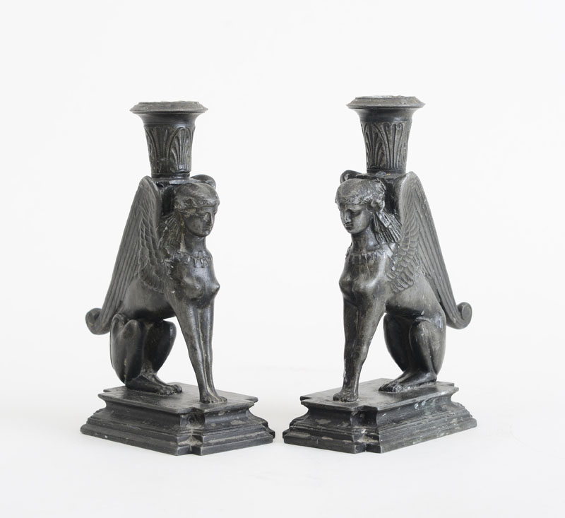 Appraisal: PAIR OF EMPIRE STYLE CAST-METAL SPHINX-FORM CANDLESTICKS Each seated winged