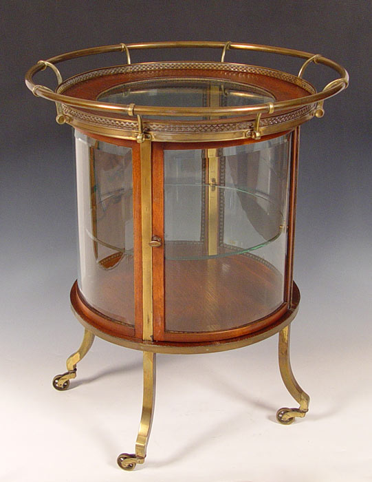 Appraisal: ROUND GLASS BRASS AND OAK VITRINE TROLLEY Four beveled glass