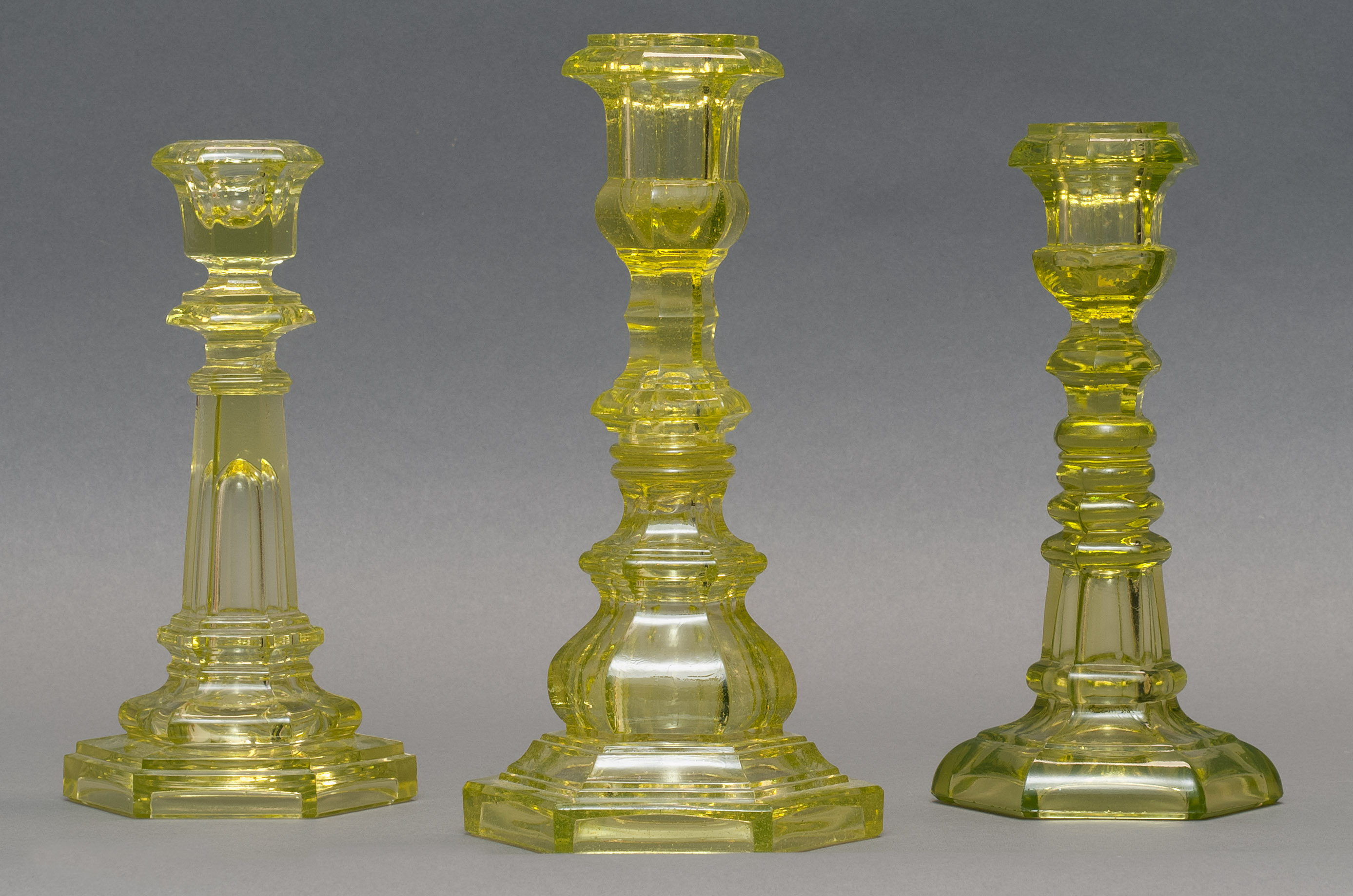 Appraisal: THREE SANDWICH GLASS COMPANY PRESSED GLASS CANDLESTICKS Mid- th CenturyIn