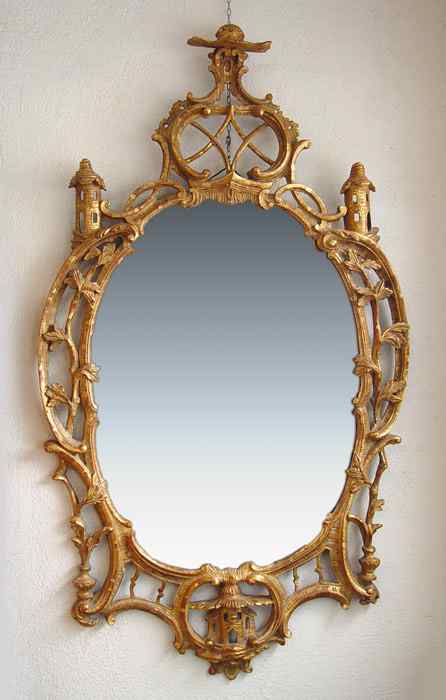 Appraisal: CARVED AND GILTWOOD OVAL MIRROR Scroll and vine frame with