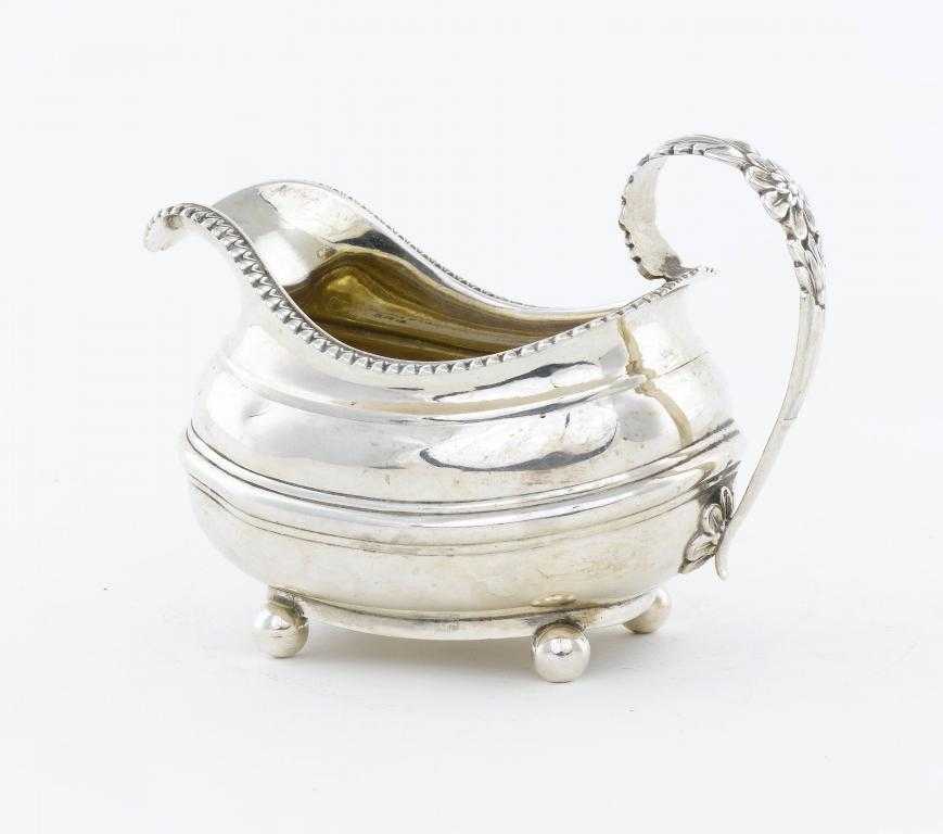 Appraisal: A GEORGE IV CREAM JUG with gadrooned rim acanthus handle