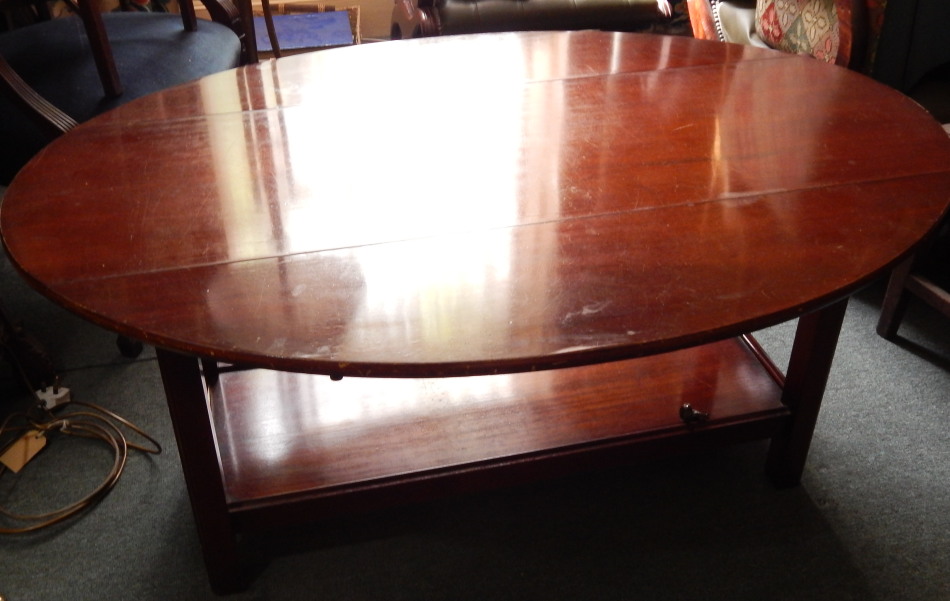 Appraisal: A mahogany coffee table the oval top with two drop