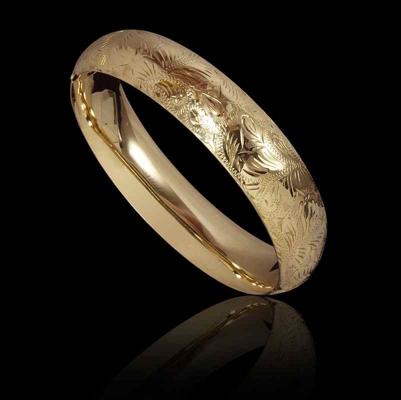 Appraisal: K GOLD ENGRAVED BANGLE BRACELET K yellow gold wide hinged