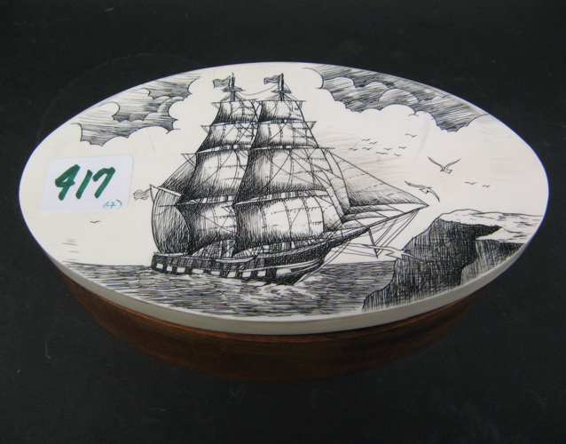 Appraisal: AN OVAL SCRIMSHAWED TRINKET BOX containing carved wood Netsuke of