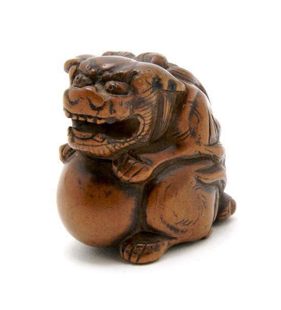 Appraisal: Carved Wood Netsuke of a Buddhistic Lion depicted atop a