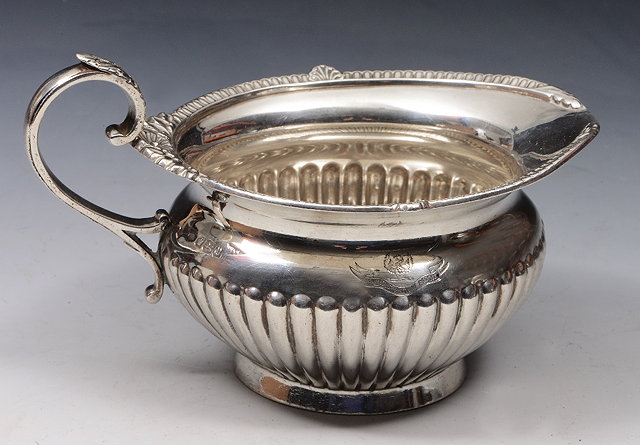 Appraisal: A GEORGE V SILVER CREAM JUG with a fluted lower