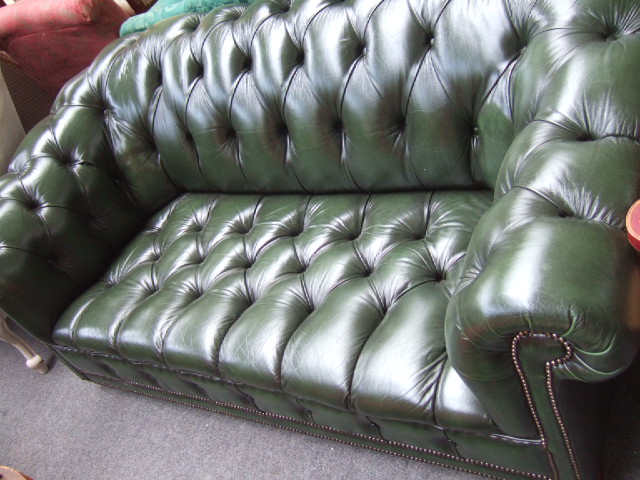 Appraisal: A th century green leather button upholstered two seat Chesterfield