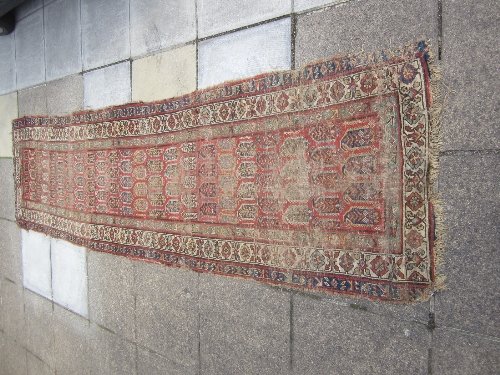 Appraisal: An Oriental runner with rows of boteh on a madder