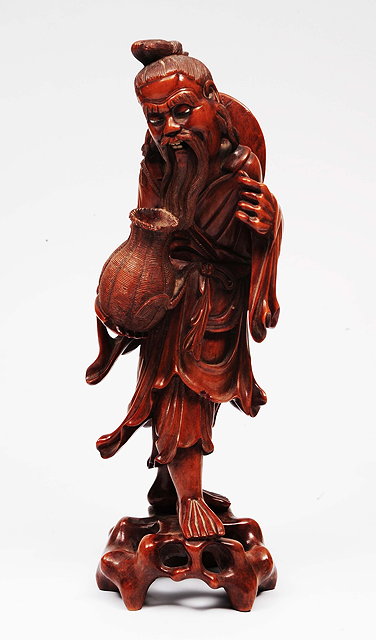 Appraisal: A Chinese carved hardwood model of a fisherman holding a