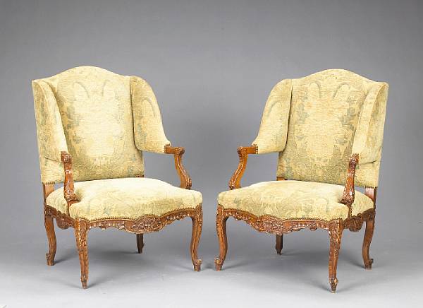 Appraisal: A pair of Louis XV style walnut fauteuil aux oreilles