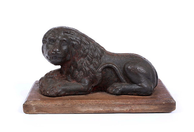 Appraisal: AN ANTIQUE CAST IRON SCULPTURE OF A RECUMBENT LION mounted