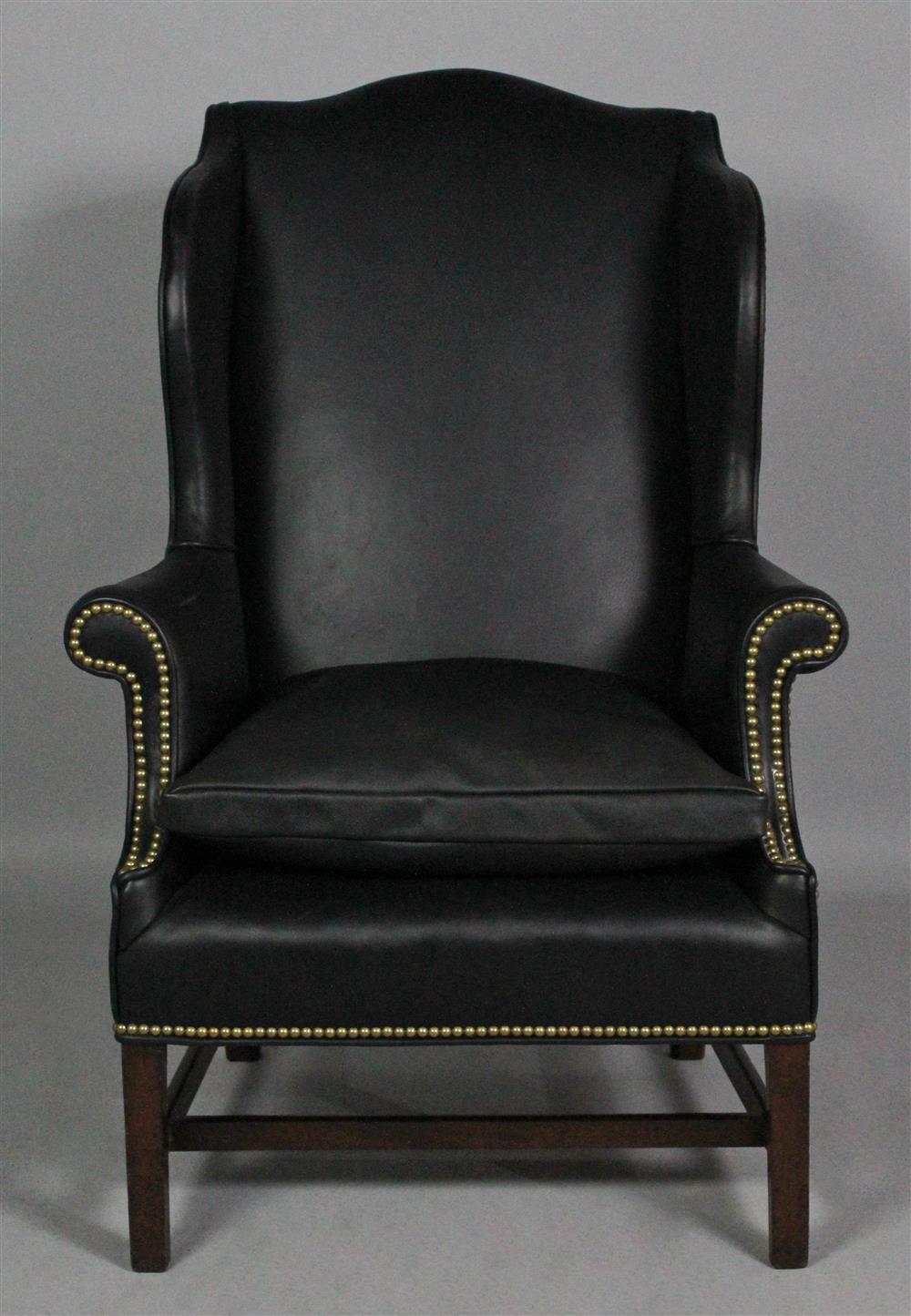 Appraisal: CHIPPENDALE STYLE BLACK LEATHER UPHOLSTERED WING CHAIR with an arching