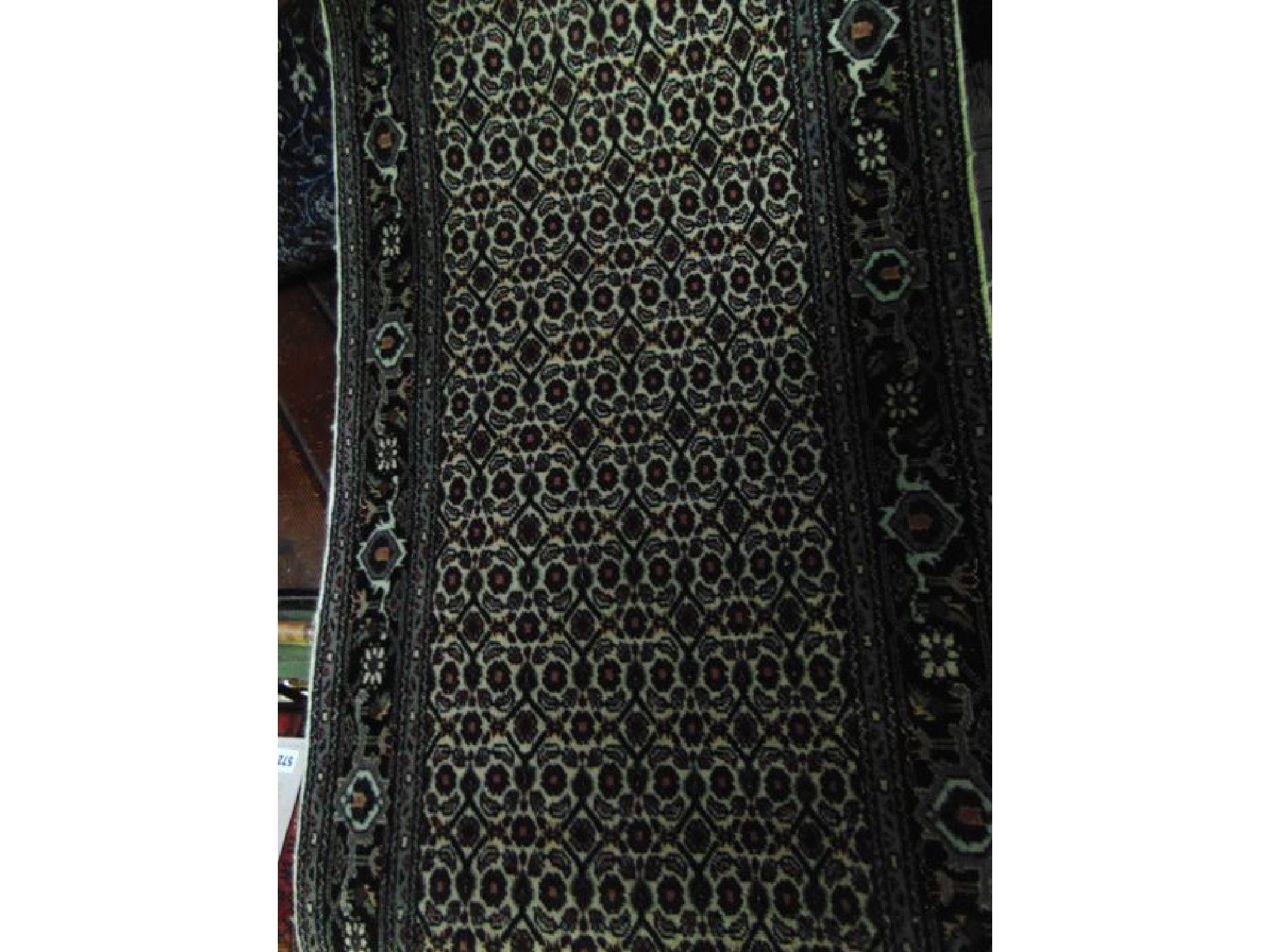 Appraisal: A Persian style wool runner with multi-floral panelled centre upon