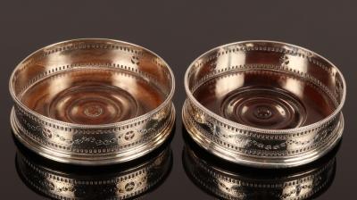 Appraisal: A pair of George III silver wine coasters HH London