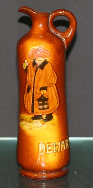 Appraisal: A Doulton Burslem Kingsware Dewars flagon decorated with a figure