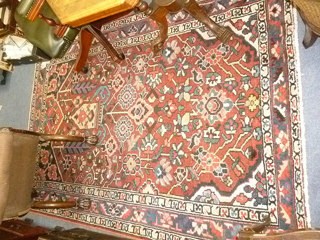 Appraisal: A BALUCHI WINE GROUND RUG with floral designs and triple