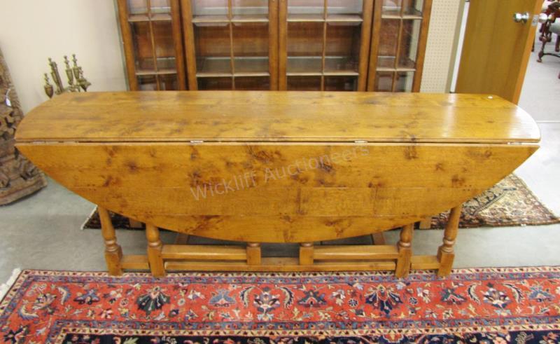 Appraisal: An antique English wake table with oval drop leaves gate