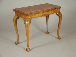 Appraisal: A walnut foldover card table mid th century the shaped