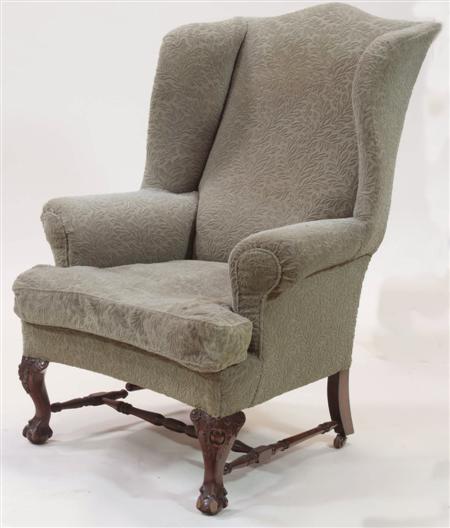 Appraisal: A large mahogany wing armchair the serpentine top rail over