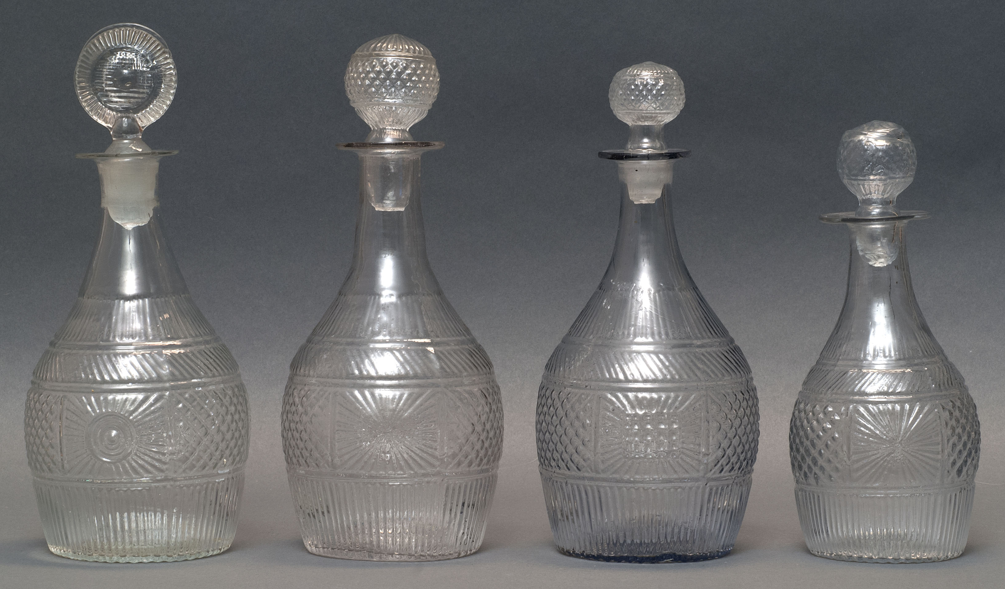 Appraisal: FOUR CLEAR GLASS BLOWN -MOLD DECANTERS Second Quarter of the