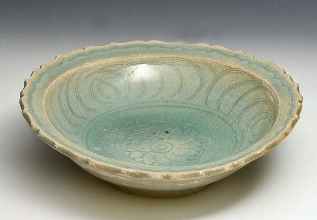 Appraisal: A THAI SAWANKALOK STONEWARE CELADON BOWL with combed lotus motifs