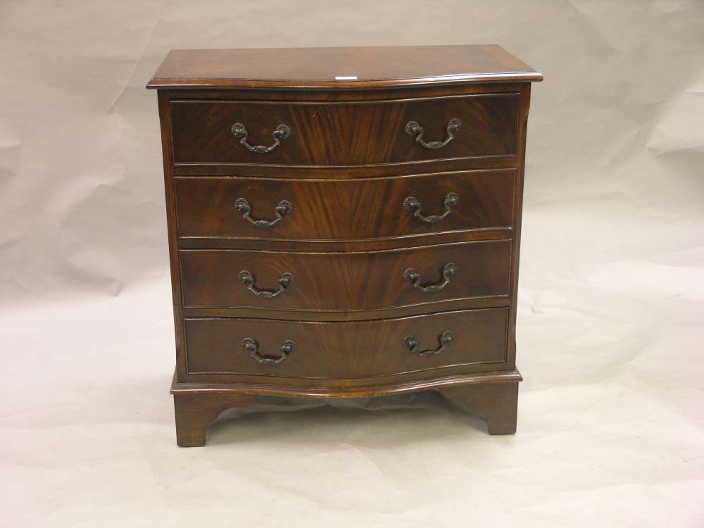 Appraisal: A reproduction mahogany veneered chest serpentine fronted with four drawers