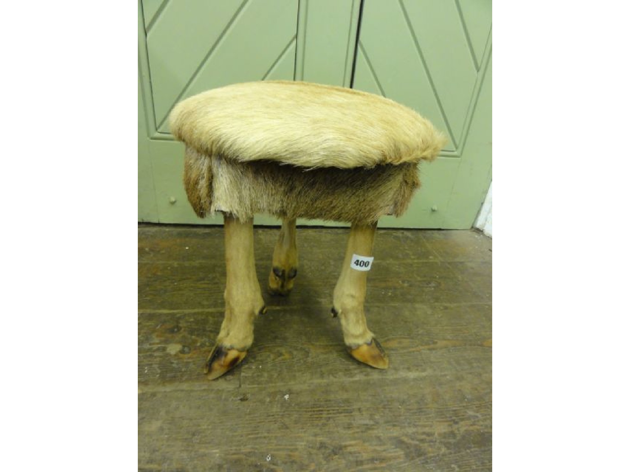 Appraisal: A small circular topped stool covered in deer hide with