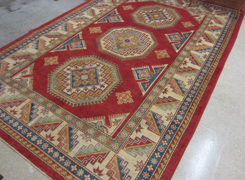 Appraisal: HAND KNOTTED ORIENTAL CARPET Pakistani Caucasian the rectangular red field