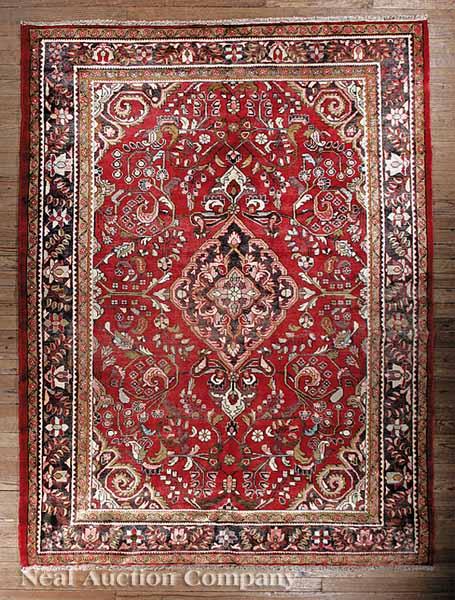 Appraisal: A Persian Lilihan Carpet red ground central medallion overall floral