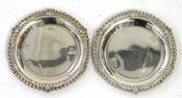 Appraisal: Pair of circular silver coasters with embossed rims London cm