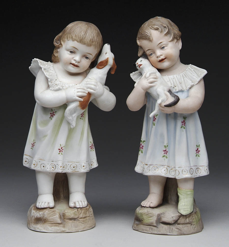 Appraisal: PAIR OF BISQUE FIGURINES OF LITTLE GIRLS AND THEIR PET