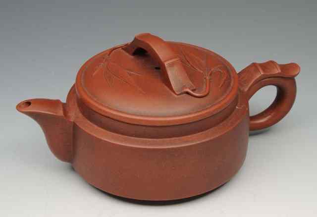 Appraisal: A CHINESE YIXING CIRCULAR TEAPOT and cover with simple bamboo