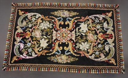 Appraisal: NEEDLEWORK LONG RUG Worked with central rosettes c-scrolls lilies and