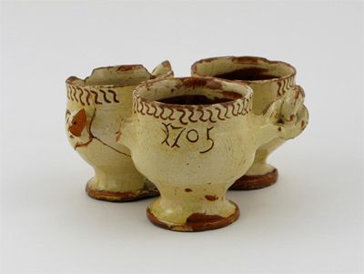 Appraisal: A North Devon slipware dated fuddling cup the three small