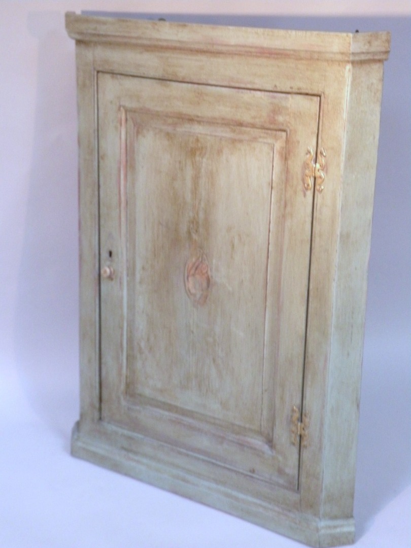 Appraisal: A thC hanging corner cupboard the panelled door centred with