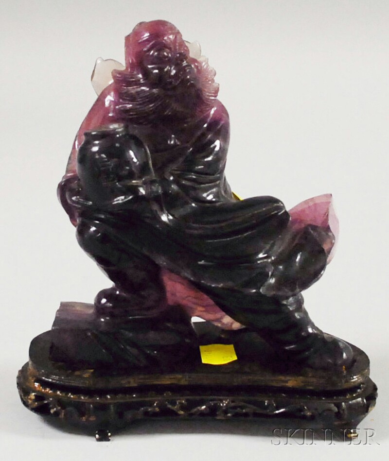 Appraisal: Asian Carved Amethyst-colored Hardstone Mythical Figure with hardwood base figure