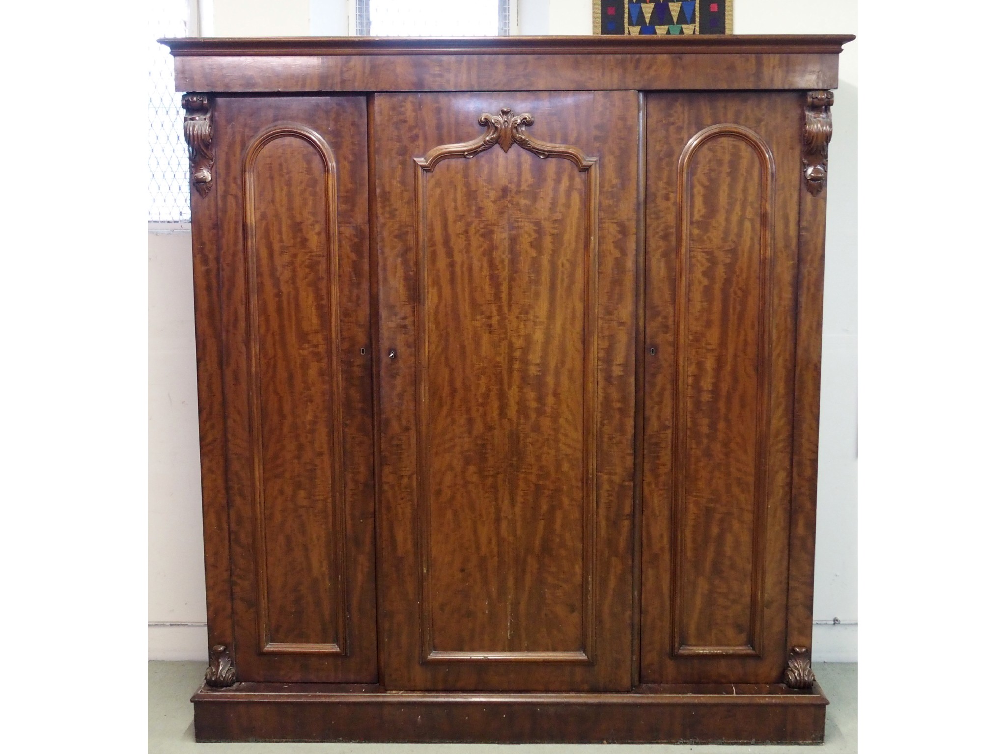 Appraisal: A Victorian mahogany three door wardrobewith raised mouldings flanked by