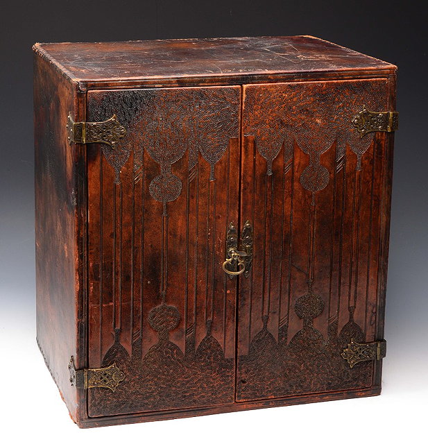 Appraisal: AN ARTS AND CRAFTS TOOLED LEATHER TABLE CABINET with decorative