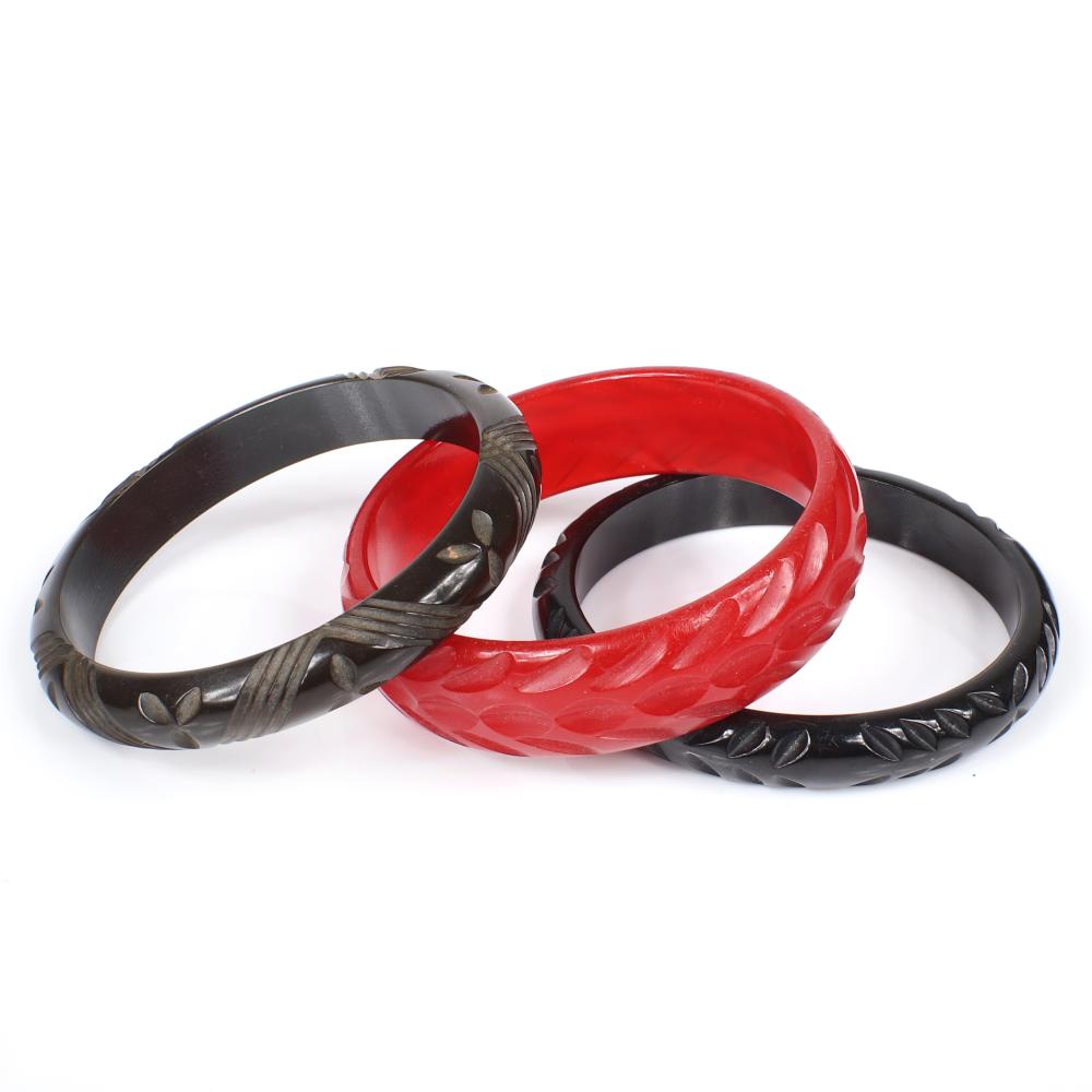 Appraisal: THREE VINTAGE BAKELITE CARVED BANGLE BRACELETS IN BLACK RED AND