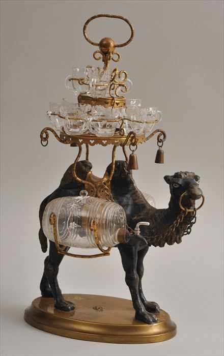 Appraisal: CONTINENTAL PAINTED POT METAL CAMEL-FORM LIQUEUR STAND The saddle with