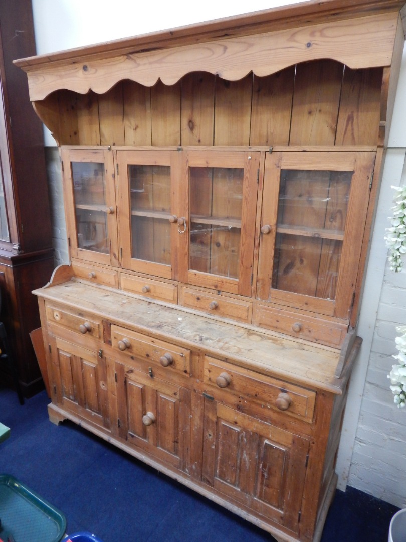 Appraisal: A pine dresser the shaped pediment over a delft rack